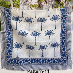 K&ouml;nnte beinhalten: Ein wei&szlig;er Baumwollstoff mit einem blauen und wei&szlig;en Palmenbaumdruck. Der Stoff hat einen blauen Rand mit einem floralen Muster. Der Text "Pattern-11" ist unten auf dem Stoff gedruckt.