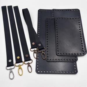 Pode incluir: Um conjunto de alças de couro preto e bases retangulares de couro com furos pré-perfurados nas bordas. As alças possuem rebites de metal e mosquetões giratórios em tons de prata, ouro e bronze para a confecção de bolsas.