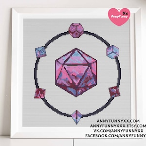 May include: A cross-stitch pattern featuring a pink and purple iridescent gemstone with a black outline. The gemstone is surrounded by six smaller gemstones in a circle.