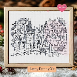 May include: A black and white cross-stitch pattern of a small town with houses and trees. The pattern is framed in a light wood frame. The text "AnnyFunnyXx" is printed below the frame.