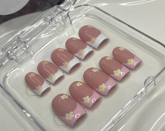 margaritas rosas y blancas presionan en las uñas