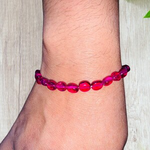 May include: A pink beaded bracelet with round beads.