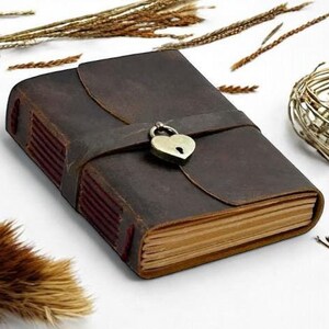 May include: A brown leather journal with a heart-shaped lock and a strap closure. The journal has a rustic look and is perfect for writing down your thoughts and ideas.
