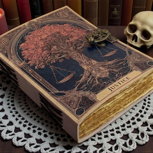 May include: A decorative book with a detailed cover featuring a tree and scales design, with the word "JUSTICE" visible. The book has aged, yellowed pages and a metal clasp. A lit candle and a skull are in the background.