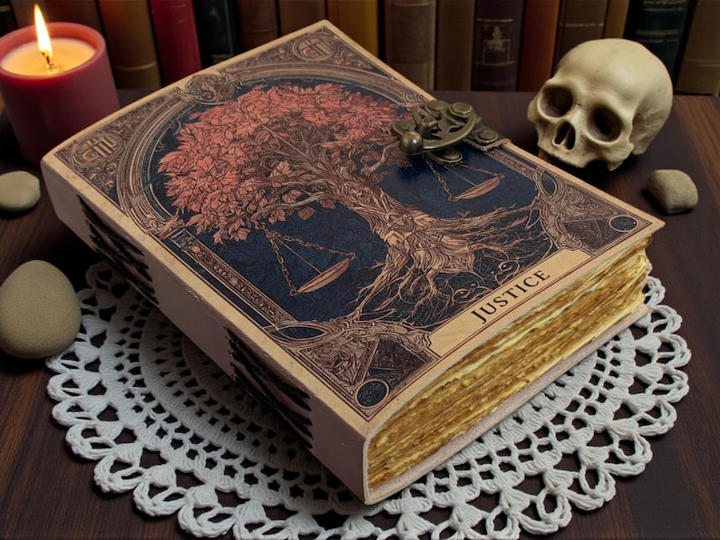 May include: A decorative book with a detailed cover featuring a tree and scales design, with the word "JUSTICE" visible. The book has aged, yellowed pages and a metal clasp. A lit candle and a skull are in the background.