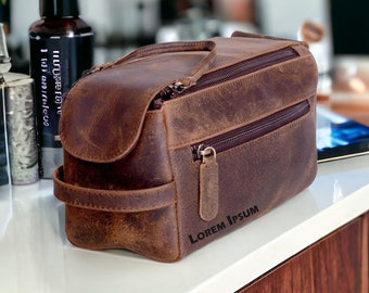 Puede incluir: Una bolsa de viaje de cuero marrón con cierre de cremallera y asa superior. La bolsa tiene un aspecto desgastado y el texto "LOREM IPSUM" está impreso en la parte inferior.