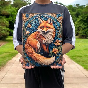May include: A vibrant orange fox with a bushy tail sits in a circular frame of blue, green, and gold floral patterns. The fox is surrounded by flowers and leaves, creating a whimsical and enchanting scene.