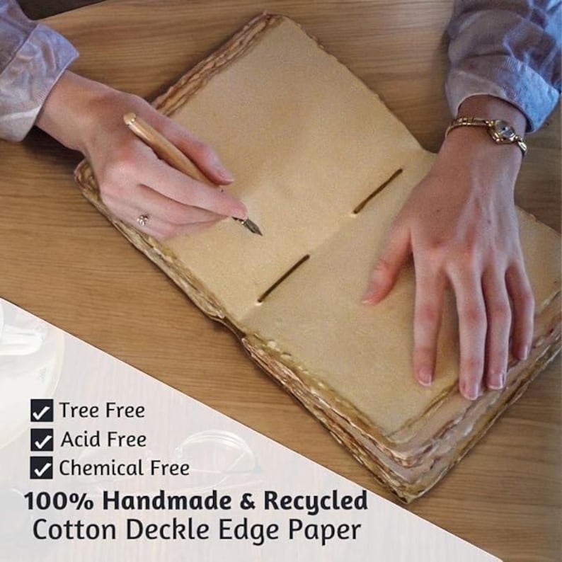 K&ouml;nnte beinhalten: Offenes handgefertigtes Baumwoll-Deckelrand-Papierjournal mit Stift. Das Journal ist baumfrei, s&auml;urefrei und chemiefrei. Das Papier hat eine hellbraune Farbe mit einem B&uuml;ttenrand. Der Text auf dem Bild lautet: 100% Handmade & Recycled Cotton Deckle Edge Paper.