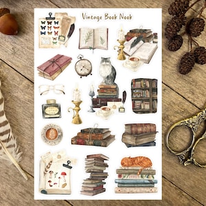 May include: Vintage Book Nook sticker sheet featuring illustrations of books, candles, a cat, a cup of tea, and a vintage clock. The sheet has the text "Vintage Book Nook" at the top.