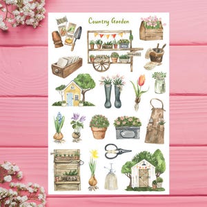 May include: A sheet of watercolor stickers with a country garden theme. The stickers feature a variety of garden items, including a wheelbarrow, a watering can, a pair of boots, a flower pot, a gardening apron, a shed, and a variety of flowers and plants. The stickers are perfect for adding a touch of whimsy to your planner, journal, or scrapbook.