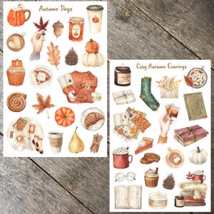 May include: Two sheets of stickers featuring autumn-themed illustrations. The first sheet is titled "Autumn Days" and features images of pumpkins, leaves, coffee, and a sweater. The second sheet is titled "Cosy Autumn Evenings" and features images of candles, books, mugs, and a blanket.
