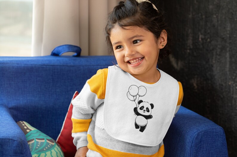 Pu&ograve; includere: Un bavaglino bianco con un orso panda bianco e nero che tiene dei palloncini. Il panda indossa un papillon rosso. Il bavaglino &egrave; indossato da un bambino piccolo con una camicia a righe gialle e bianche.