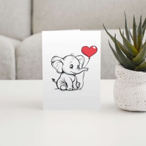 May include: A black and white illustration of a cute elephant holding a red heart-shaped balloon. The elephant is sitting down and looking to the right.
