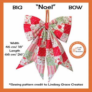 May include: A large fabric bow with a patchwork design featuring red, white, and green Christmas-themed patterns, including poinsettias and stripes. The bow measures 46 cm in width and 68 cm in length, with the text BIG NOEL BOW visible.