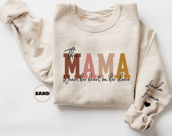 Custom This Mama Wears Her Heart On Her Sleeve Sweatshirt, Personalized Mom Hoodie With Kids Names, Cute Momma Outfit, Mothers Day Gift Idea