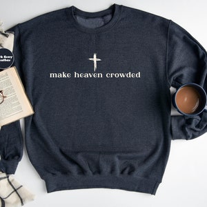 May include: Dark grey heather sweatshirt with a white cross and the text "make heaven crowded".