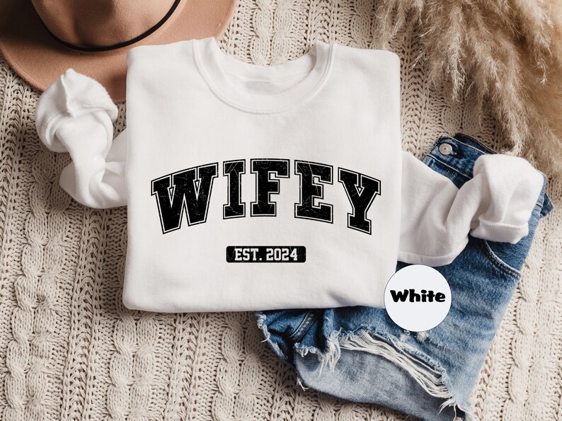 May include: White sweatshirt with black text that reads "WIFEY EST. 2024".