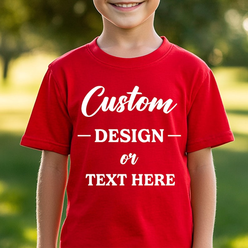 Puede incluir: Una camiseta roja con la palabra "Custom" en escritura blanca en el pecho. Debajo, el texto dice "- DESIGN - or TEXT HERE" en blanco, lo que sugiere un dise&ntilde;o personalizable. La camiseta es de manga corta.