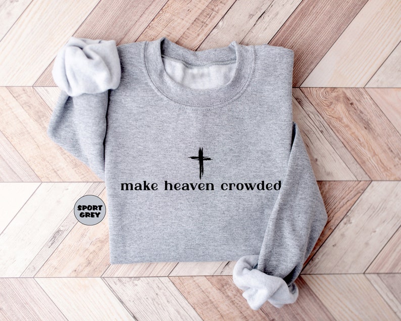 May include: A grey sweatshirt with a black cross and the text "make heaven crowded" printed on the front.