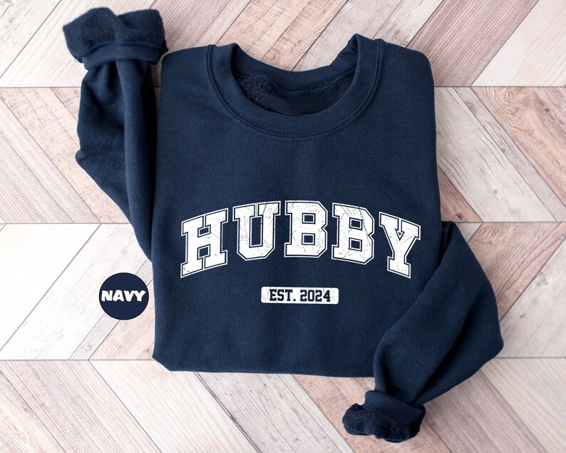 May include: Navy blue sweatshirt with white text that reads "HUBBY EST. 2024".