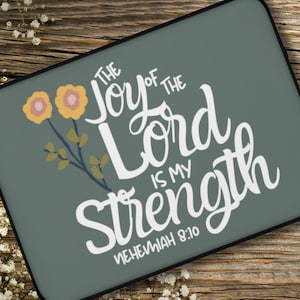 Puede incluir: Una funda para portátil de color verde azulado con un diseño floral blanco y el texto "The Joy of the Lord is my Strength, Nehemiah 8:10".