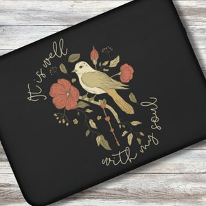 May include: A black laptop sleeve with a floral design featuring a bird and the text "It is well with my soul".