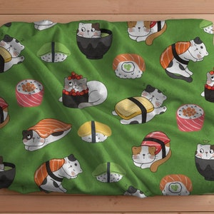 Op de afbeelding: Groene stof met een herhalend patroon van katten die sushi eten. De katten zijn getekend in een cartoon-stijl en dragen verschillende gekleurde outfits. De sushi is gemaakt van verschillende ingrediënten, waaronder vis, rijst en zeewier.