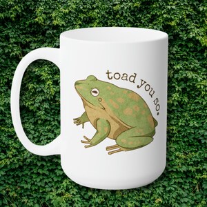 May include: White ceramic mug featuring a green and brown cartoon toad with the text "toad you so."