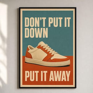 May include: A framed poster featuring a low-top sneaker with cream and orange panels. The background is divided into a teal upper section and a rust-orange lower section. The text reads DON'T PUT IT DOWN in cream at the top and PUT IT AWAY at the bottom.