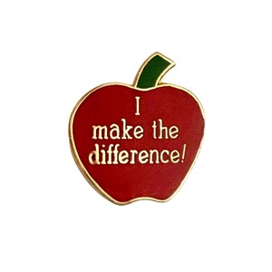 May include: Red apple-shaped enamel pin with a gold outline. The pin says "I make the difference!" in gold lettering.