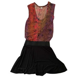 May include: Sleeveless dress with a scoop neck. The top features a colorful pattern in shades of red, orange, and purple. The skirt is solid black, and the waist is defined by a black band. The dress is made of a lightweight material.