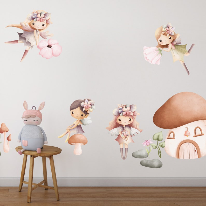 May include: A set of six wall decals featuring fairies and mushrooms. The fairies are wearing floral crowns and have wings. The mushrooms are brown and have white spots. The decals are perfect for adding a touch of whimsy to a child's room.