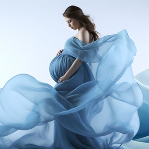 May include: A pregnant woman in a flowing light blue gown poses against a backdrop of blue and white waves. The gown is made of a sheer fabric that billows around her.