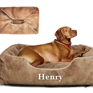 Dog reclining on light brown faux fur personalized dog bed cover with embroidered name Henry; washable and removable, this custom dog bed accessory adds comfort and style to modern dog beds or pet furniture, making it a cozy upgrade or thoughtful pet gift.