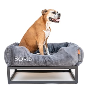 Dark grey elevated dog bed with black raised dog bed frame and plush faux fur washable dog bed cover. This orthopedic dog bed works as a dog window perch, platform dog bed, or modern dog bed for large dogs. Raised dog bed design improves airflow and comfort while washable dog bed cover makes cleaning easy. Perfect as a big dog bed, extra large dog bed, or stylish custom dog bed for pets.