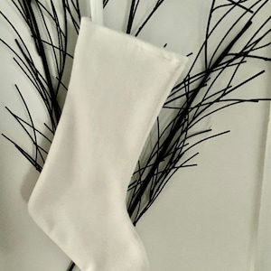 May include: A white Christmas stocking with a loop at the top.
