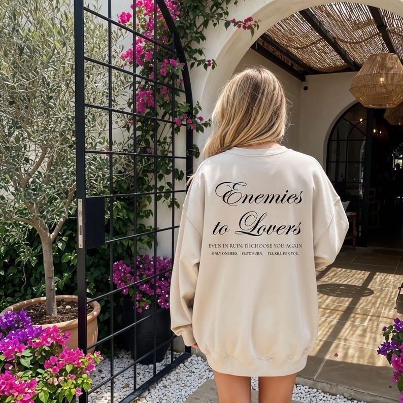 Minimalistisch “Enemies to Lovers” tekstdesign op hoodie, sweatshirt of T-shirt voor romance readers. Perfect voor fans van de enemies-to-lovers trope en bookish fashion. Zacht, comfortabel en ideaal om te dragen tijdens het lezen. Stijlvol cadeau voor boekenliefhebbers.