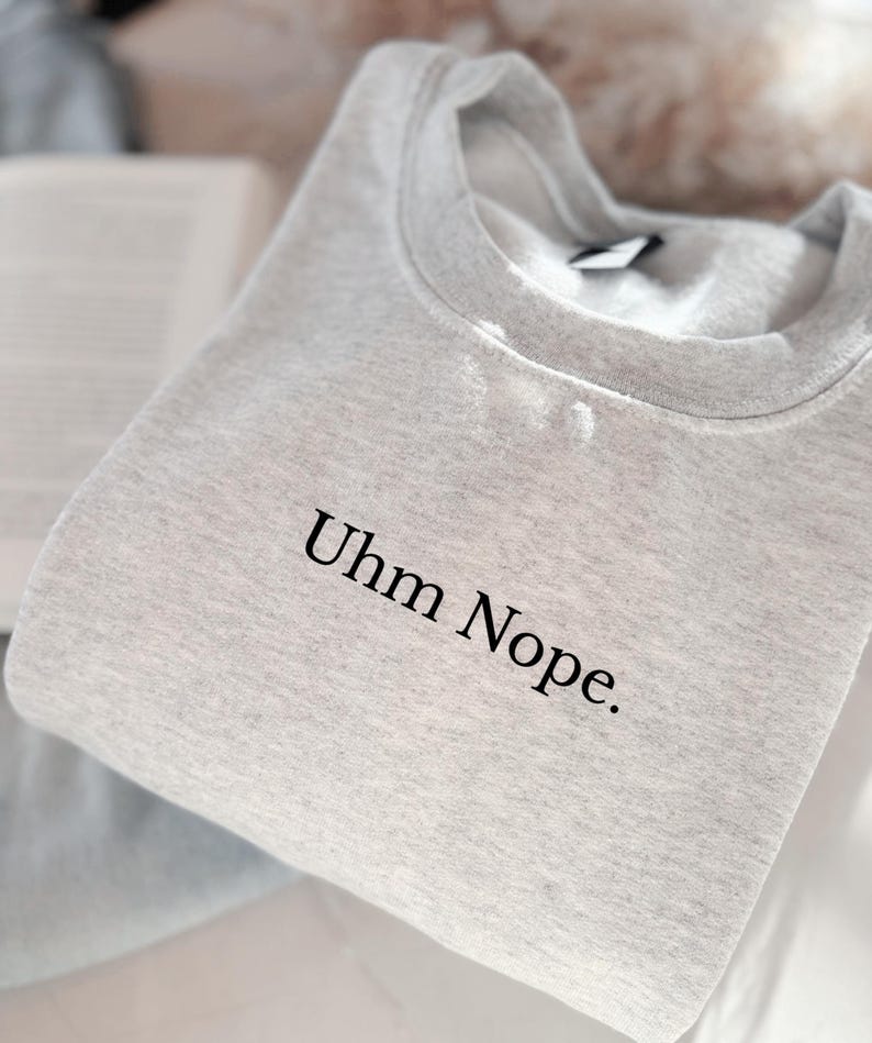Geborduurd sweatshirt met de tekst “Uhm Nope.” in een minimalistisch lettertype. De trui heeft een comfortabele pasvorm en een rustige, stijlvolle uitstraling. Het ontwerp straalt humor, zelfbeschikking en duidelijke grenzen uit. Geschikt voor casual outfits, relaxmomenten of als origineel cadeau voor iemand die vandaag gewoon even nee zegt.