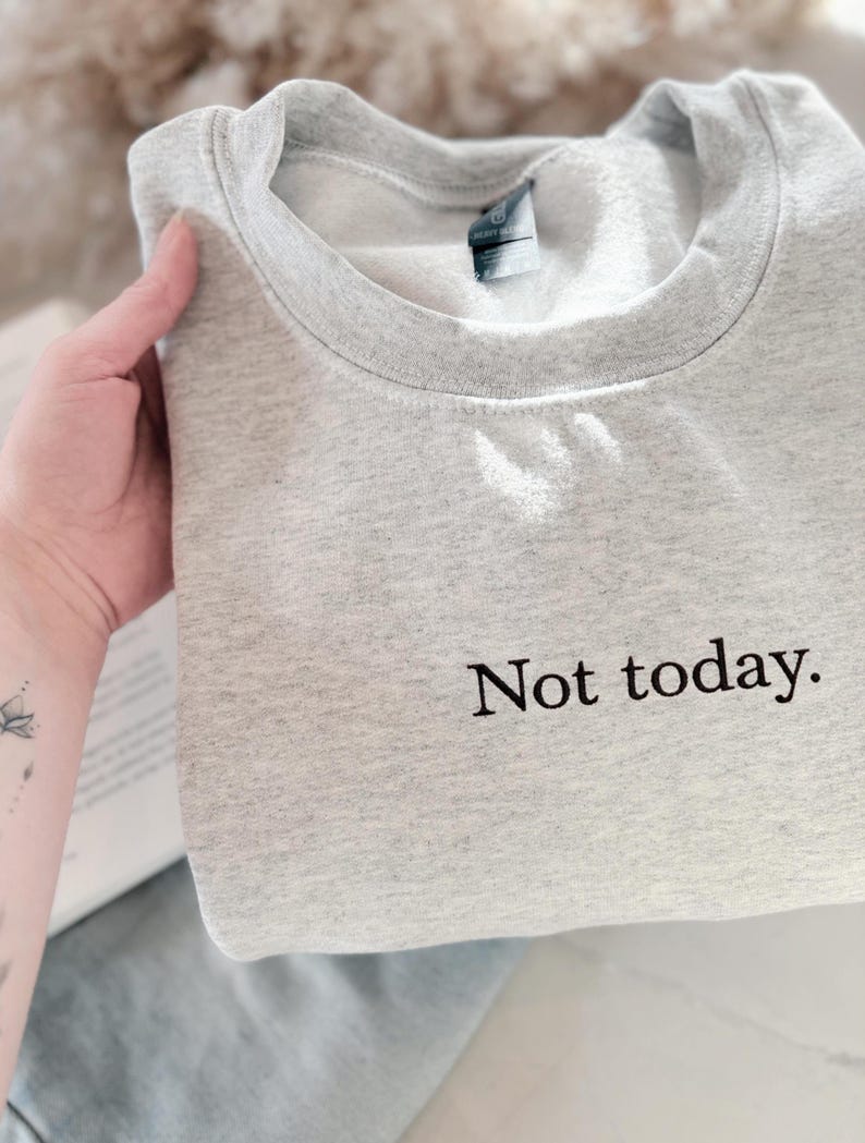 Grappige statement T-shirt met de tekst “Not today” in een minimalistisch en modern lettertype. Het ontwerp straalt humor, zelfverzekerdheid en duidelijke grenzen uit. Geschikt als casual outfit of comfy sweatshirtlook. Perfect als cadeau voor je vriendin of voor jezelf, voor iedereen die met een knipoog nee durft te zeggen. Tijdloos, stijlvol en makkelijk te combineren.