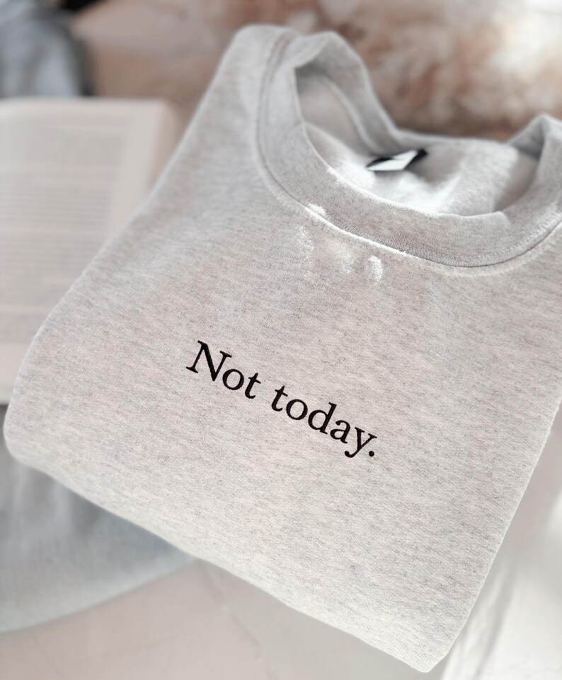 Grappige statement T-shirt met de tekst “Not today” in een minimalistisch en modern lettertype. Het ontwerp straalt humor, zelfverzekerdheid en duidelijke grenzen uit. Geschikt als casual outfit of comfy sweatshirtlook. Perfect als cadeau voor je vriendin of voor jezelf, voor iedereen die met een knipoog nee durft te zeggen. Tijdloos, stijlvol en makkelijk te combineren.