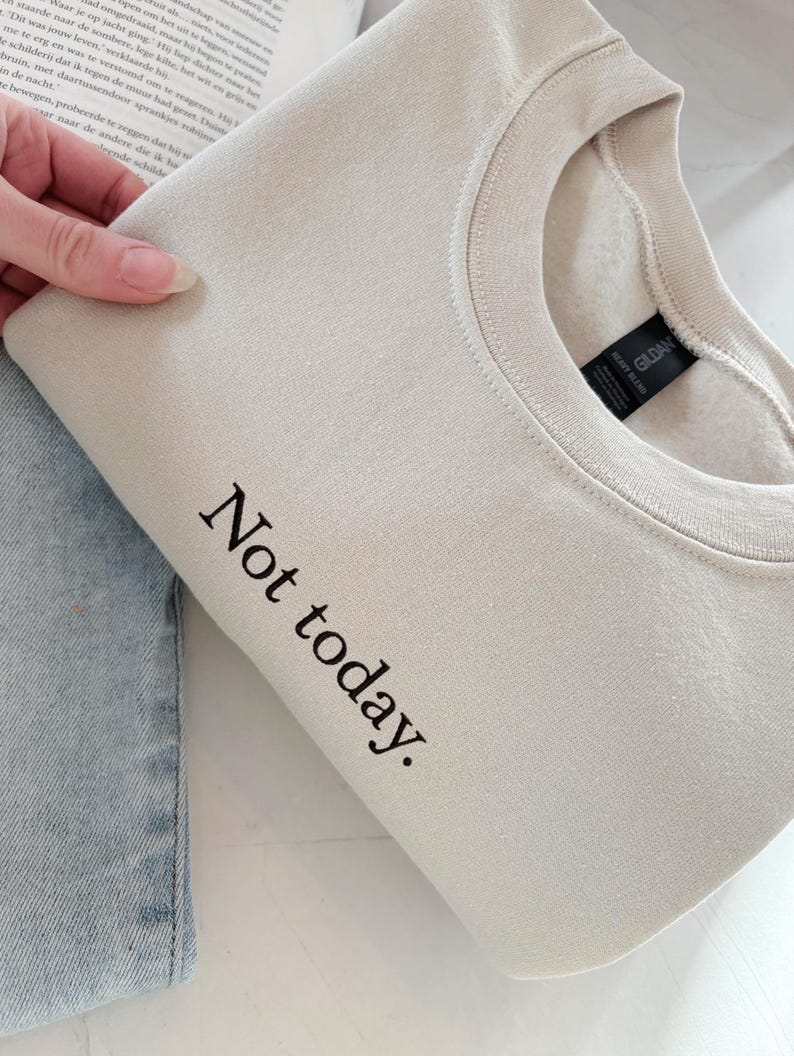 Grappige statement T-shirt met de tekst “Not today” in een minimalistisch en modern lettertype. Het ontwerp straalt humor, zelfverzekerdheid en duidelijke grenzen uit. Geschikt als casual outfit of comfy sweatshirtlook. Perfect als cadeau voor je vriendin of voor jezelf, voor iedereen die met een knipoog nee durft te zeggen. Tijdloos, stijlvol en makkelijk te combineren.