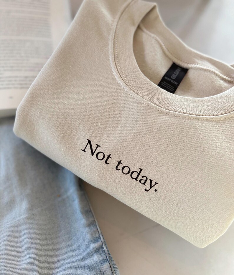 Grappige statement T-shirt met de tekst “Not today” in een minimalistisch en modern lettertype. Het ontwerp straalt humor, zelfverzekerdheid en duidelijke grenzen uit. Geschikt als casual outfit of comfy sweatshirtlook. Perfect als cadeau voor je vriendin of voor jezelf, voor iedereen die met een knipoog nee durft te zeggen. Tijdloos, stijlvol en makkelijk te combineren.