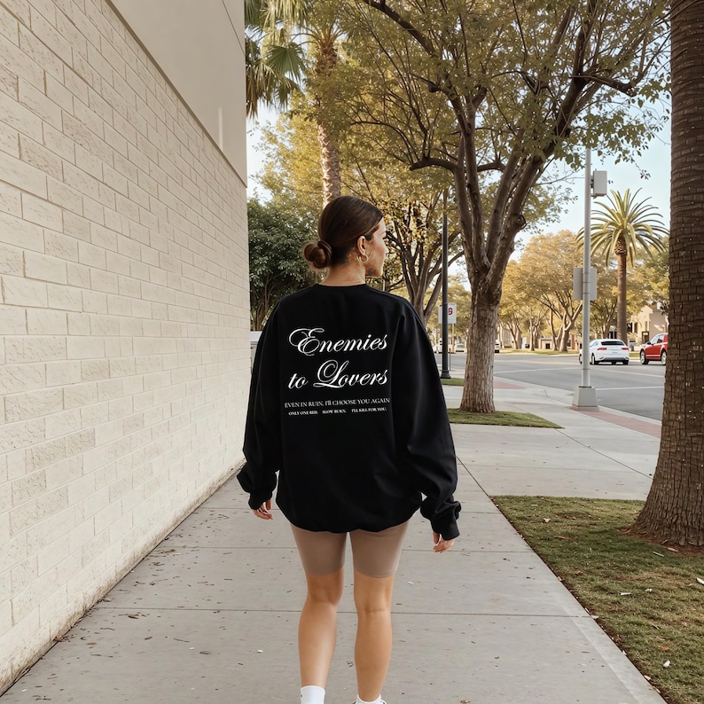 Minimalistisch “Enemies to Lovers” tekstdesign op hoodie, sweatshirt of T-shirt voor romance readers. Perfect voor fans van de enemies-to-lovers trope en bookish fashion. Zacht, comfortabel en ideaal om te dragen tijdens het lezen. Stijlvol cadeau voor boekenliefhebbers.