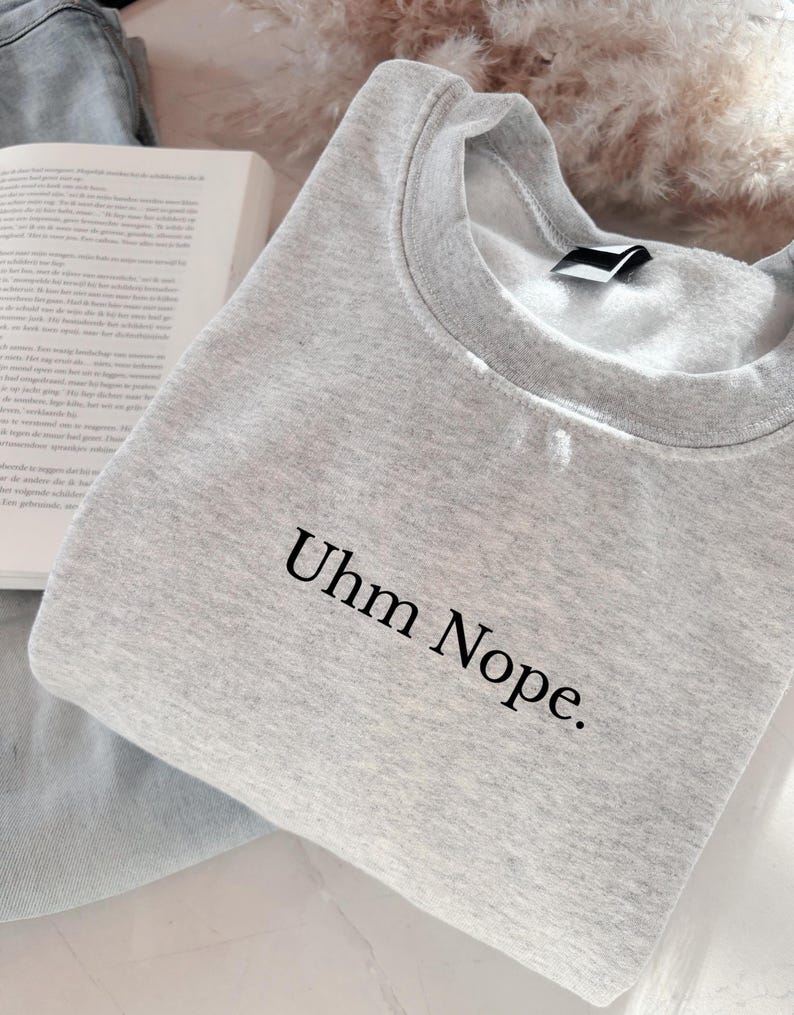 Geborduurd sweatshirt met de tekst “Uhm Nope.” in een minimalistisch lettertype. De trui heeft een comfortabele pasvorm en een rustige, stijlvolle uitstraling. Het ontwerp straalt humor, zelfbeschikking en duidelijke grenzen uit. Geschikt voor casual outfits, relaxmomenten of als origineel cadeau voor iemand die vandaag gewoon even nee zegt.