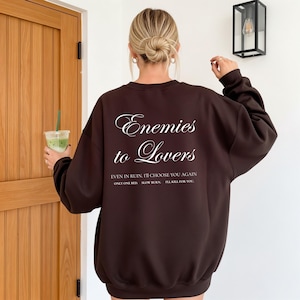 Minimalistisch “Enemies to Lovers” tekstdesign op hoodie, sweatshirt of T-shirt voor romance readers. Perfect voor fans van de enemies-to-lovers trope en bookish fashion. Zacht, comfortabel en ideaal om te dragen tijdens het lezen. Stijlvol cadeau voor boekenliefhebbers.