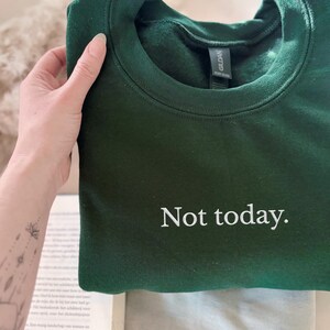 Grappige statement T-shirt met de tekst “Not today” in een minimalistisch en modern lettertype. Het ontwerp straalt humor, zelfverzekerdheid en duidelijke grenzen uit. Geschikt als casual outfit of comfy sweatshirtlook. Perfect als cadeau voor je vriendin of voor jezelf, voor iedereen die met een knipoog nee durft te zeggen. Tijdloos, stijlvol en makkelijk te combineren.