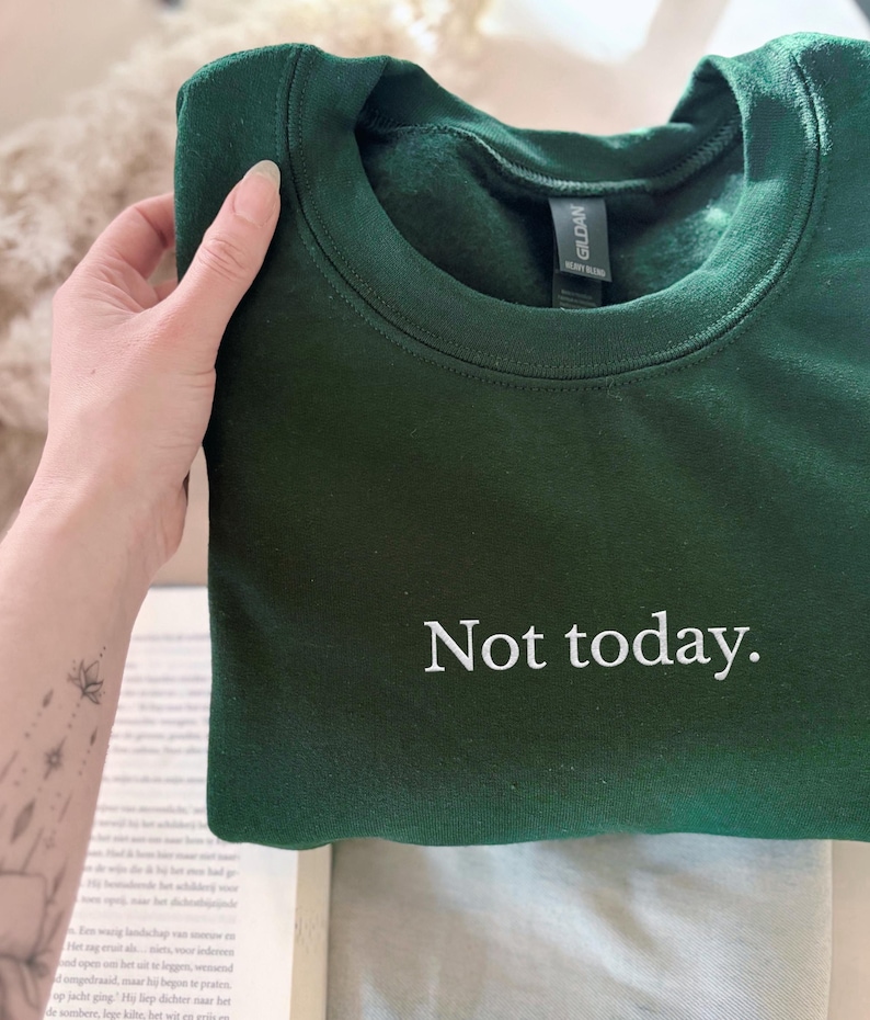 Grappige statement T-shirt met de tekst “Not today” in een minimalistisch en modern lettertype. Het ontwerp straalt humor, zelfverzekerdheid en duidelijke grenzen uit. Geschikt als casual outfit of comfy sweatshirtlook. Perfect als cadeau voor je vriendin of voor jezelf, voor iedereen die met een knipoog nee durft te zeggen. Tijdloos, stijlvol en makkelijk te combineren.