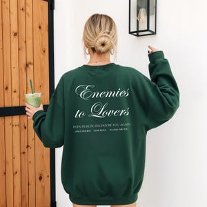 Minimalistisch “Enemies to Lovers” tekstdesign op hoodie, sweatshirt of T-shirt voor romance readers. Perfect voor fans van de enemies-to-lovers trope en bookish fashion. Zacht, comfortabel en ideaal om te dragen tijdens het lezen. Stijlvol cadeau voor boekenliefhebbers.