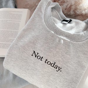 Grappige statement T-shirt met de tekst “Not today” in een minimalistisch en modern lettertype. Het ontwerp straalt humor, zelfverzekerdheid en duidelijke grenzen uit. Geschikt als casual outfit of comfy sweatshirtlook. Perfect als cadeau voor je vriendin of voor jezelf, voor iedereen die met een knipoog nee durft te zeggen. Tijdloos, stijlvol en makkelijk te combineren.