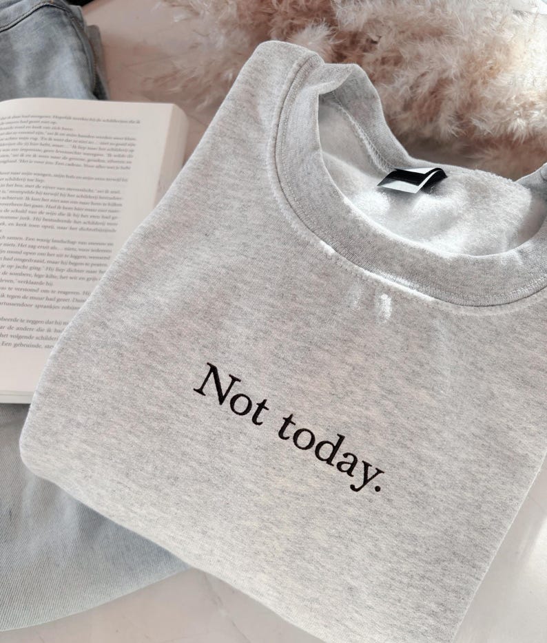 Grappige statement T-shirt met de tekst “Not today” in een minimalistisch en modern lettertype. Het ontwerp straalt humor, zelfverzekerdheid en duidelijke grenzen uit. Geschikt als casual outfit of comfy sweatshirtlook. Perfect als cadeau voor je vriendin of voor jezelf, voor iedereen die met een knipoog nee durft te zeggen. Tijdloos, stijlvol en makkelijk te combineren.